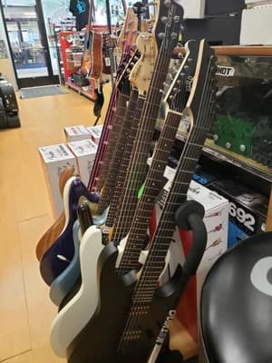 Electric guitars racked on the shop floor at Big Island Guitars